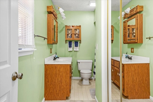 full bath with tile patterned floors, a textured ceiling, toilet, and a sink