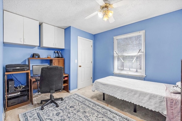 bedroom featuring baseboards, light carpet, a textured ceiling, and ceiling fan