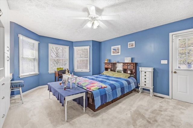 carpeted bedroom featuring baseboards, a textured ceiling, and ceiling fan