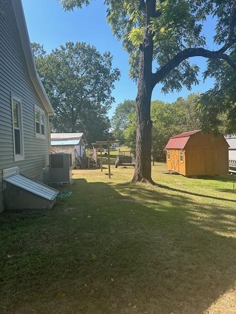 view of yard with a storage shed and an outbuilding