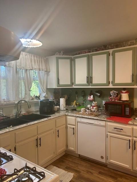 kitchen with white appliances, wood finished floors, a sink, white cabinetry, and light countertops