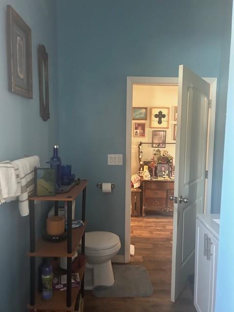 bathroom with toilet and wood finished floors