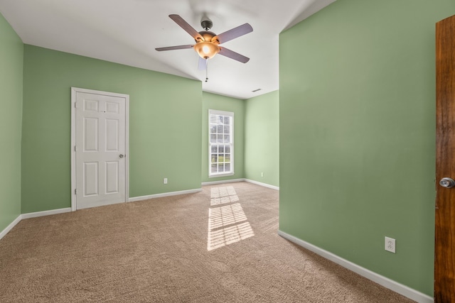 carpeted spare room featuring lofted ceiling and ceiling fan