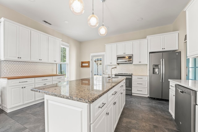 kitchen featuring tasteful backsplash, stainless steel appliances, and white cabinets