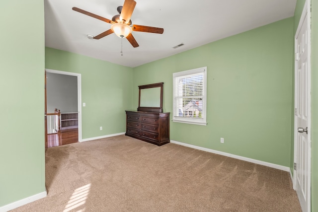 unfurnished bedroom featuring light colored carpet and ceiling fan