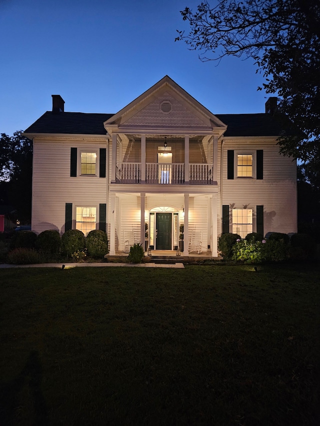 exterior space with a balcony and a front yard