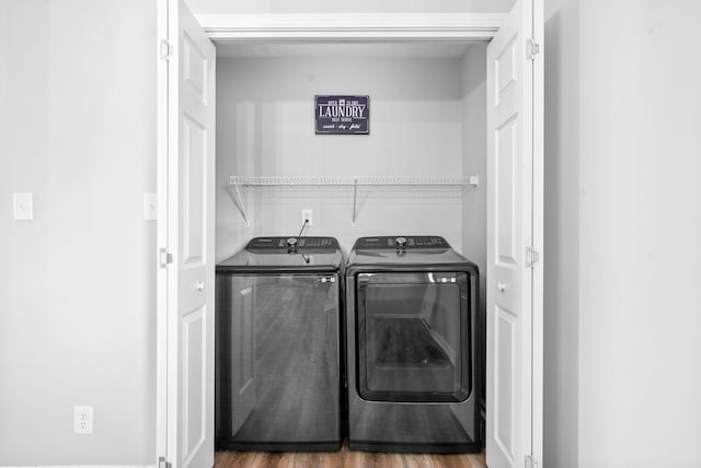 laundry room with dark wood-type flooring and separate washer and dryer