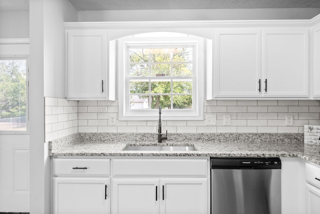 kitchen with white cabinets, a wealth of natural light, sink, and stainless steel dishwasher