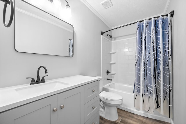 full bathroom featuring toilet, hardwood / wood-style floors, vanity, a textured ceiling, and shower / bath combo