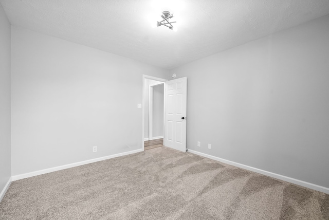 empty room with carpet and a textured ceiling