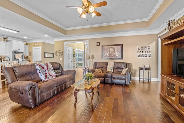 living room with ornamental molding, a textured ceiling, hardwood / wood-style floors, and ceiling fan