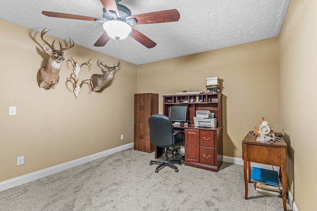 office area featuring a textured ceiling, ceiling fan, and light carpet