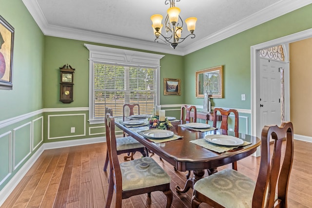 dining area featuring crown molding, a textured ceiling, hardwood / wood-style floors, and a notable chandelier