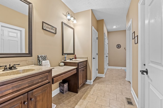 bathroom featuring tile patterned flooring, a textured ceiling, and vanity