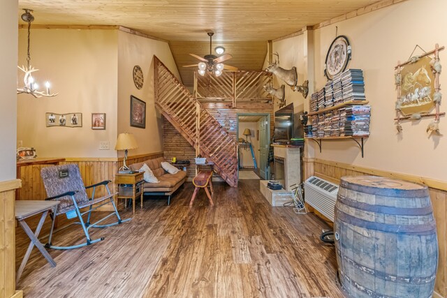 interior space featuring wooden ceiling, hardwood / wood-style floors, ceiling fan with notable chandelier, wood walls, and high vaulted ceiling