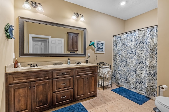 bathroom with a textured ceiling, vanity, walk in shower, toilet, and tile patterned floors