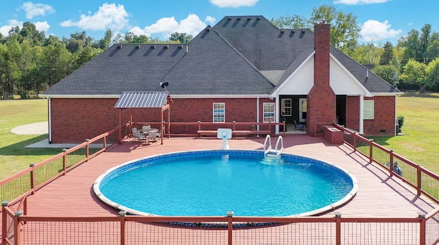 view of pool with a wooden deck, a lawn, and a patio