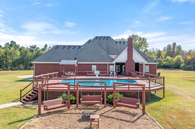 view of swimming pool with a wooden deck and a lawn