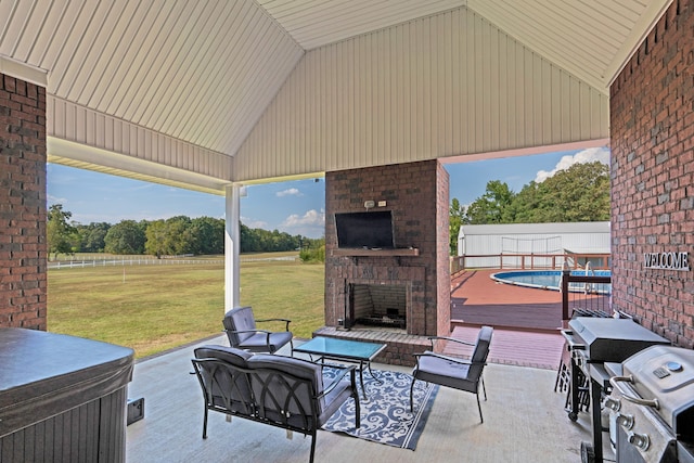 view of patio / terrace featuring a fenced in pool and an outdoor brick fireplace