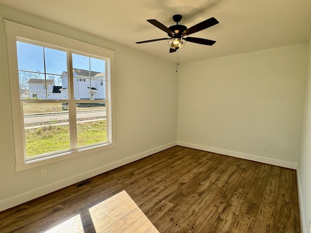 empty room with ceiling fan and dark wood-type flooring