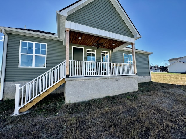 rear view of house featuring ceiling fan and a porch