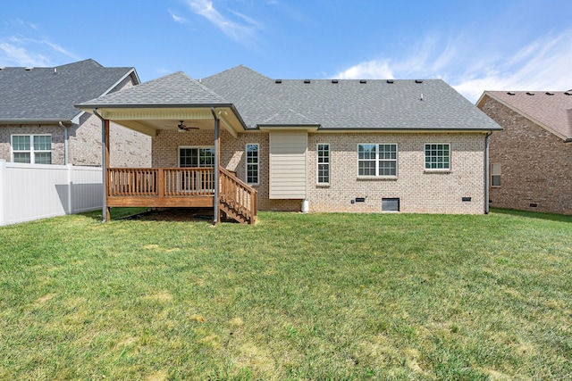 rear view of property with a lawn, a deck, and ceiling fan