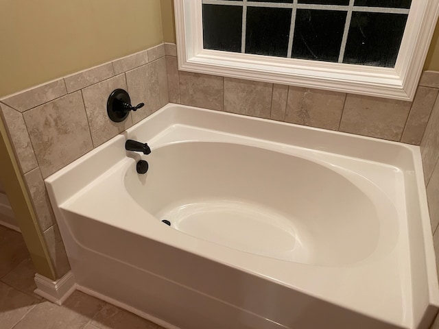 bathroom with a bath and tile patterned floors