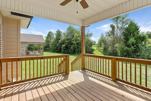 deck with a lawn and ceiling fan