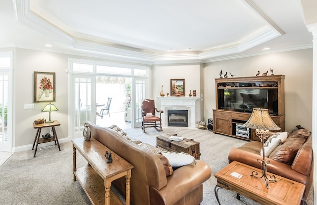 living room featuring ornamental molding, a raised ceiling, and carpet flooring