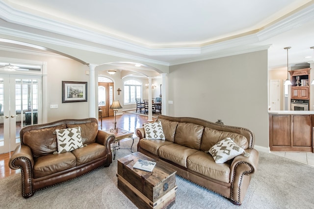 living room with a wealth of natural light, ornamental molding, french doors, and ornate columns