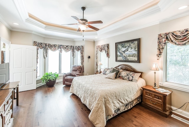 bedroom featuring ceiling fan, dark hardwood / wood-style floors, a raised ceiling, and ornamental molding