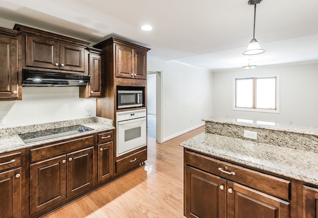 kitchen featuring black appliances, pendant lighting, light hardwood / wood-style flooring, and dark brown cabinetry