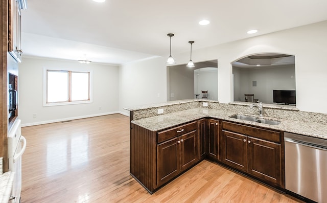 kitchen featuring decorative light fixtures, light stone counters, light hardwood / wood-style floors, sink, and stainless steel dishwasher