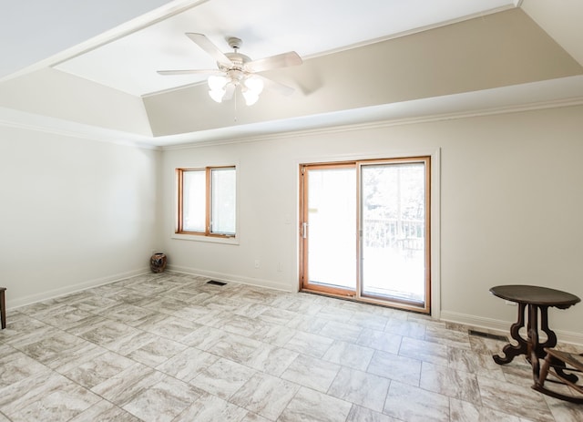 spare room with crown molding, lofted ceiling, a tray ceiling, and ceiling fan