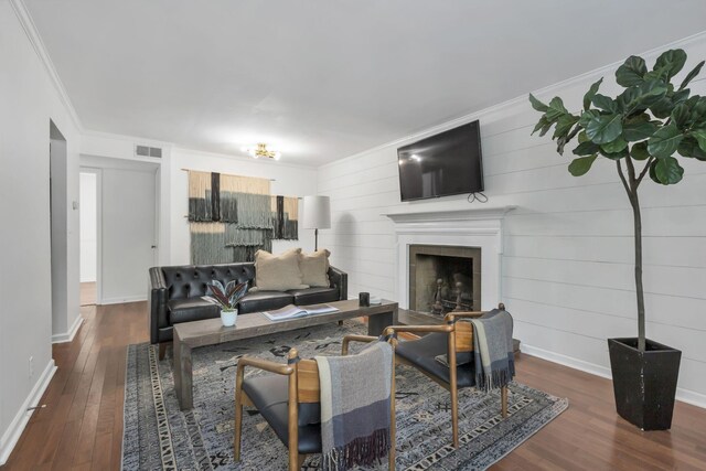 living room featuring ornamental molding, dark hardwood / wood-style flooring, and wood walls