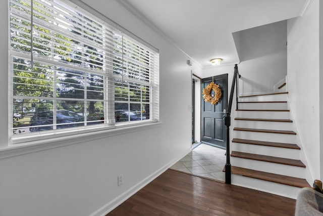 foyer featuring crown molding, plenty of natural light, and hardwood / wood-style floors