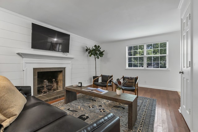 living room featuring ornamental molding, wood walls, dark hardwood / wood-style floors, and a fireplace