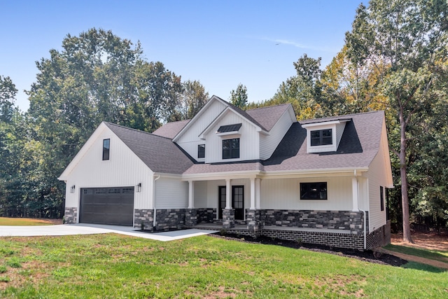 view of front of property featuring a garage, a porch, and a front lawn