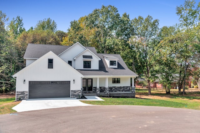 modern farmhouse featuring a garage, a front lawn, and a porch