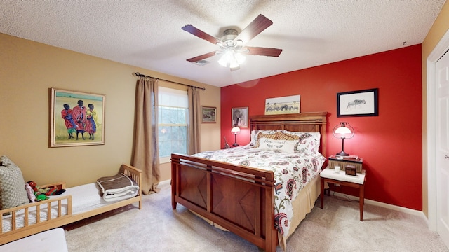 bedroom with a textured ceiling, light colored carpet, and ceiling fan