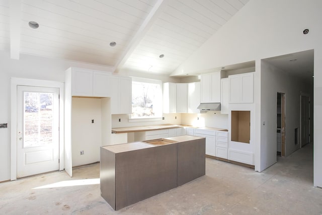 kitchen featuring beam ceiling, plenty of natural light, white cabinetry, and a kitchen island