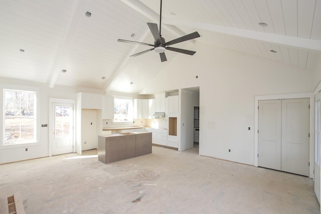 kitchen featuring ceiling fan, a kitchen island, beamed ceiling, high vaulted ceiling, and white cabinets