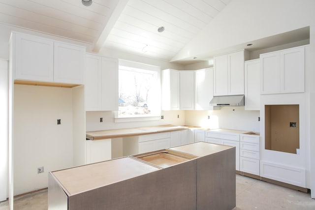 kitchen featuring vaulted ceiling with beams, a kitchen island, white cabinetry, and stovetop