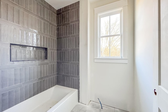 bathroom with tile patterned flooring and a bathtub