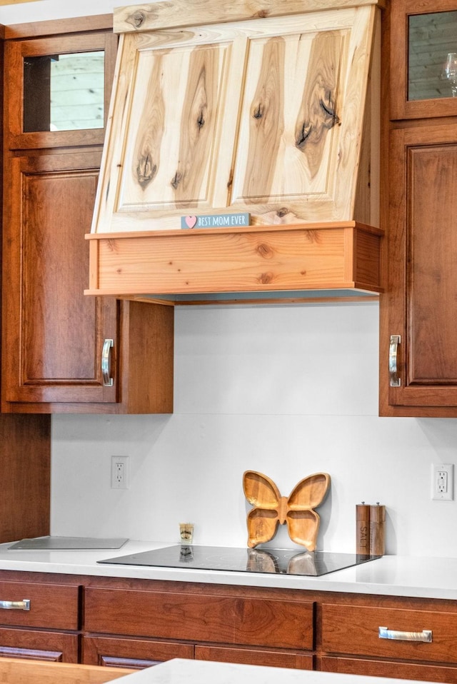 kitchen with light countertops, black electric cooktop, and brown cabinets