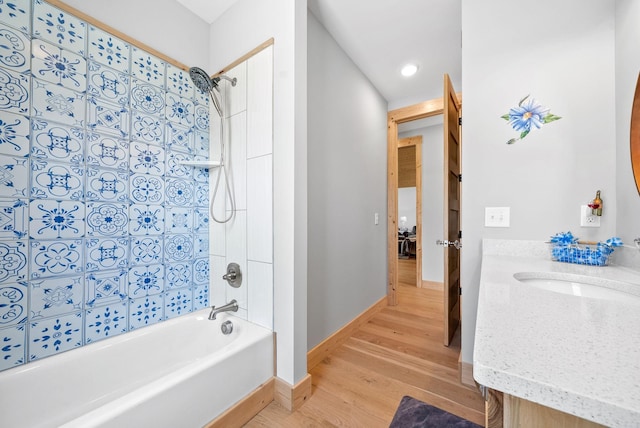 full bathroom with bathing tub / shower combination, wood finished floors, vanity, and baseboards