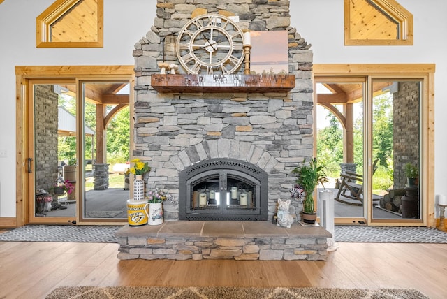 unfurnished living room featuring a healthy amount of sunlight, wood-type flooring, and a fireplace