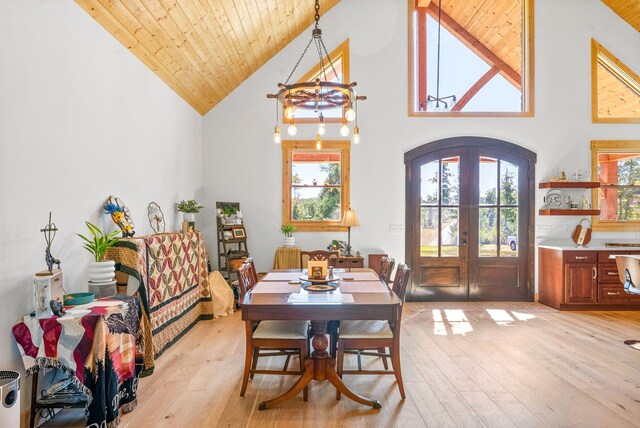 dining space with wood ceiling, french doors, plenty of natural light, and light wood finished floors