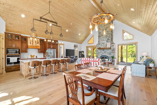 dining room with wooden ceiling, high vaulted ceiling, a wealth of natural light, and light wood-style floors