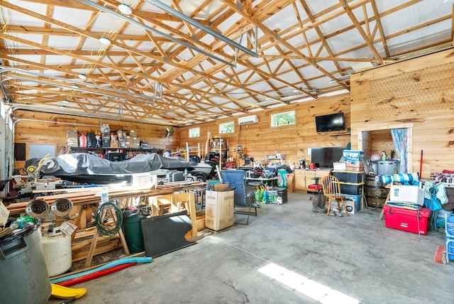 garage featuring a wall unit AC, wooden walls, and a workshop area